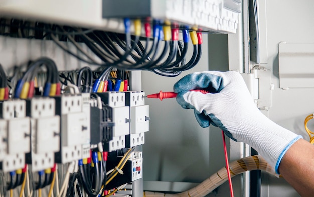 Electrical engineer checking the operation of electrical control cabinet, maintenance concept.