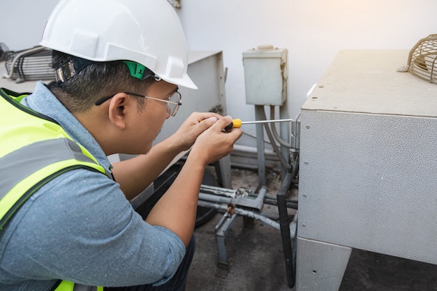 Electrical engineer is checking and maintenance air conditioner system.