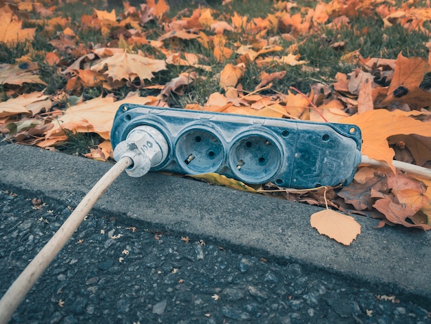 Electrical outlet of construction electric cable lies on the street with electric plug on socket