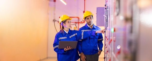 Electrical switch panel room Asian Electrical Engineer and worker team working with laptop computer for service and maintenance in HVAC control panels room at new modern building and factory