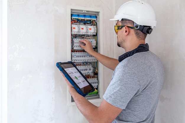 Electrical technician looking focused while working in a switchboard with fuses