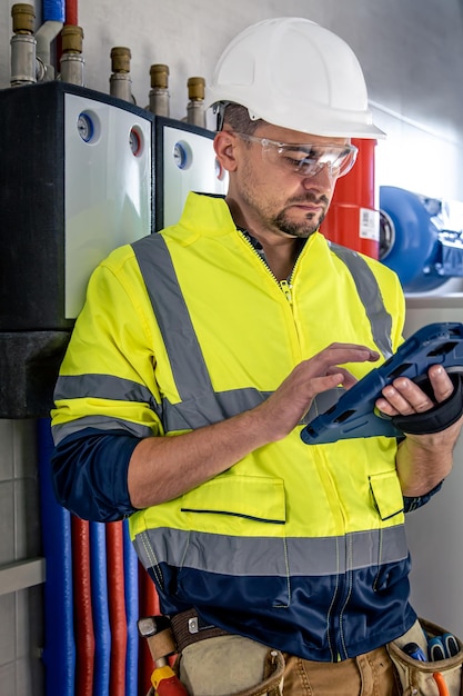 Electrical technician looking focused while working in a switchboard with fuses