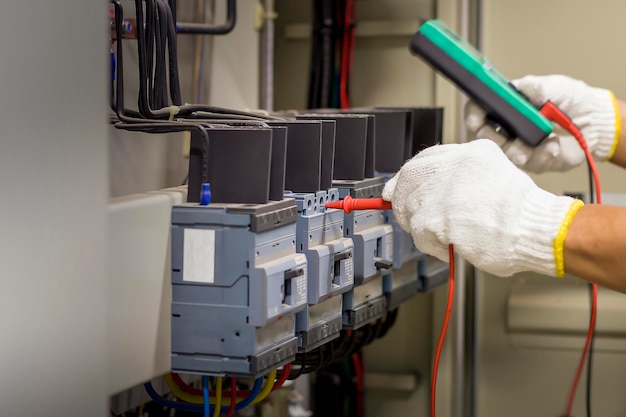 electrician checking the operation of electrical control equipment, maintenance concept.