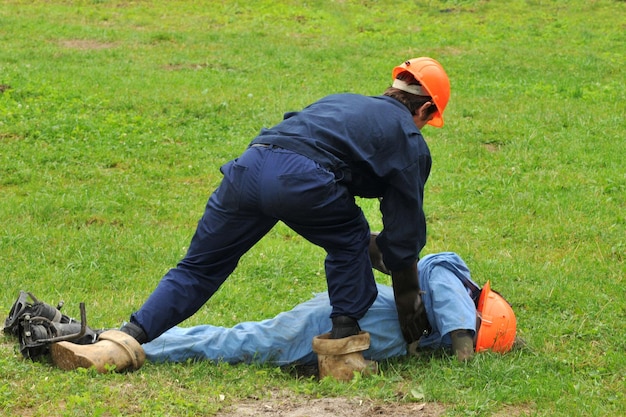 An electrician helps a victim of electric shock. Training on a dummy.