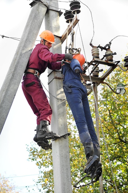 An electrician helps the worker affected by an electric shock. Training on a mannequin.