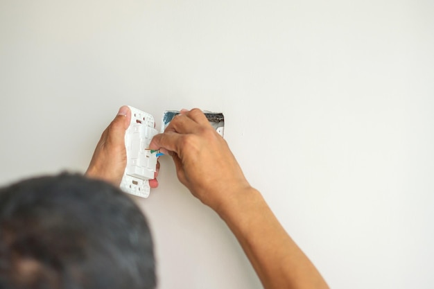 Electrician installing Wire cables for socket plug to a concrete Renovation Repair service and development of home and apartment concepts