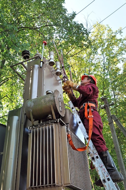 The electrician installs the ground on the power line before repairing the substation