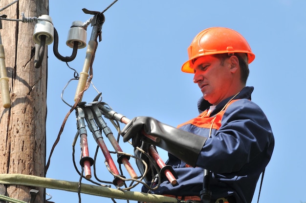 Photo an electrician is preparing to install grounding on a power line