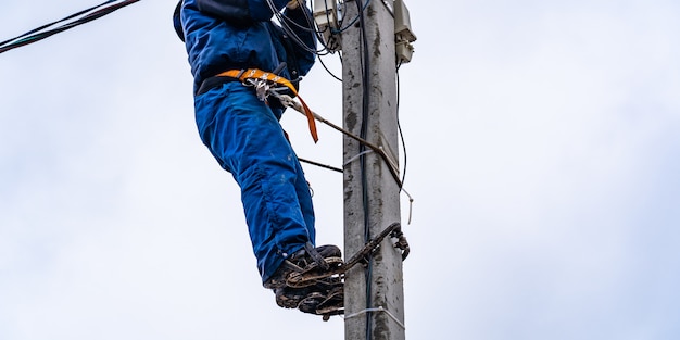 The electrician vysotnik makes installation of power grids