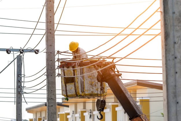 The electrician went up to the crane basket to install the power cord.