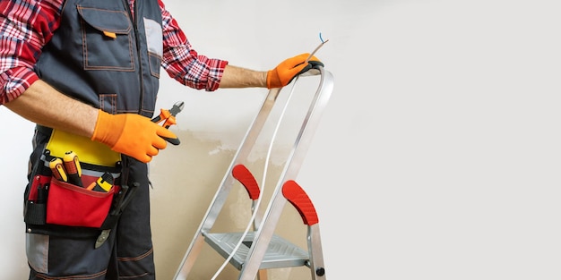 Electrician working on the electrical installation of a house panoramic banner with copy space selective focus