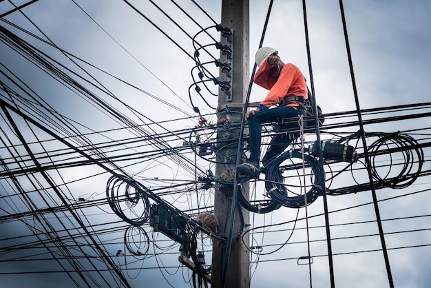 Electricians are climbing on electric poles to install and repair power lines