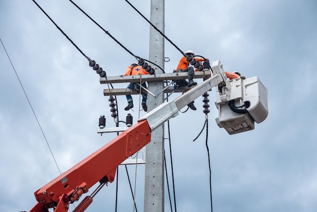 Electricians are climbing on electric poles to install and repair power lines