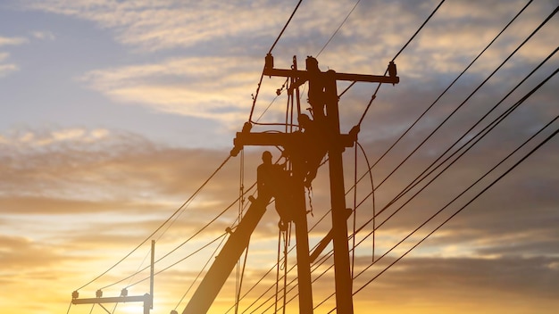 Electricians work on high voltage towers to install wires and equipment