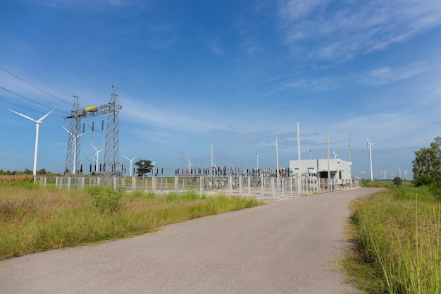 Electricity pylons and power plant or station with wind turbine in nature outdoor