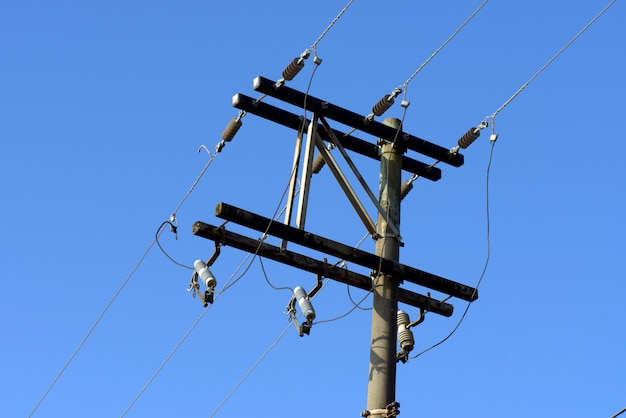 Electricity transmission pole under blue sky