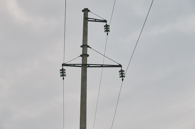 Electricity transmission pole silhouetted against blue sky at dusk