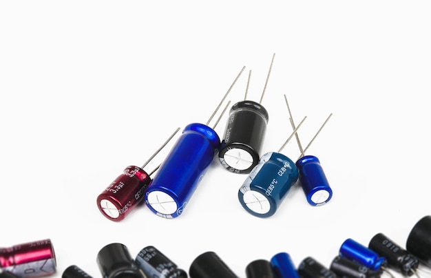 Electrolytic or electrolyte capacitors heap on white background electronic parts concept