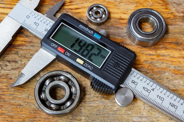 Electronic caliper with ball bearings on a wooden table in the workshop