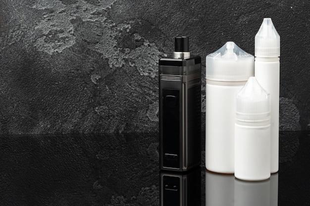 Electronic cigarette with refill liquid bottles on gray background