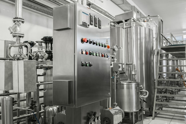 Electronic control panel and tank at a milk factory. equipment at the dairy plant