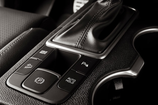 Electronic handbrake button on a new car with luxurious and modern details