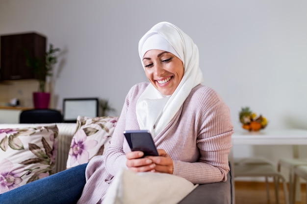 Elegant attractive female muslim using mobile smartphone searching online information