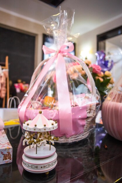 Elegant Baby Shower Gift Basket with Pink Bow and Carousel on Table