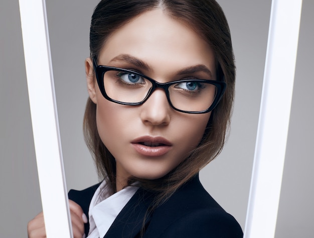 Elegant beautiful woman in a black fashionable suit and glasses