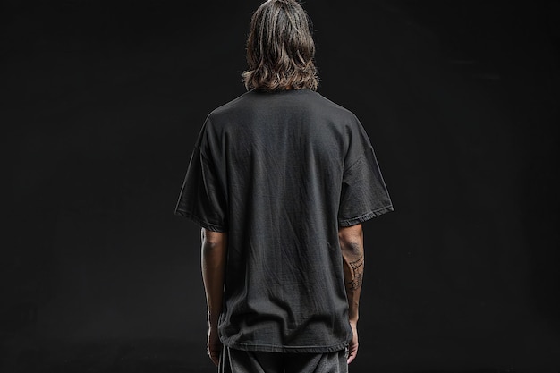 Elegant Black oversized tshirt mockup on solid black background back view of tall man in short s