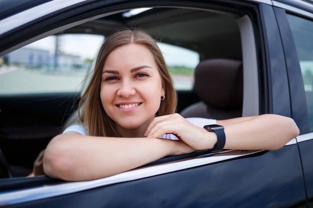 Elegant blonde beautiful woman sitting in a luxury car. The girl is stylish and earns a lot. independent woman businessman concept