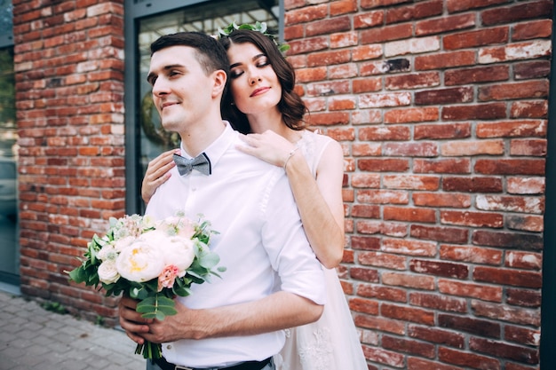 Elegant bride and groom posing together outdoors on a wedding day