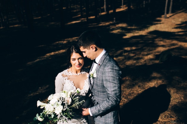 Elegant bride and groom posing together outdoors on a wedding day