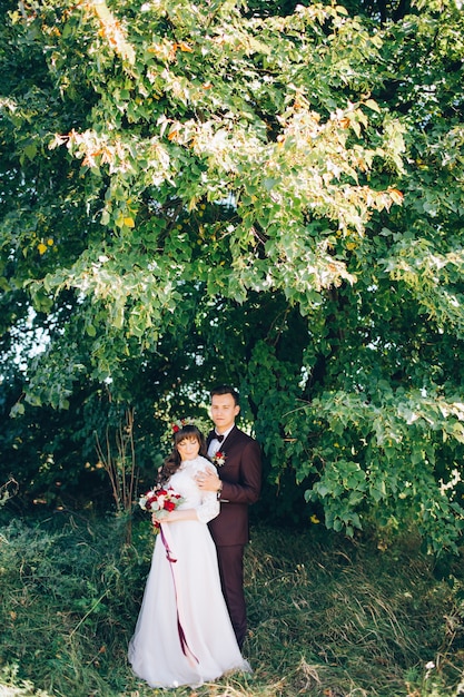 Elegant bride and groom posing together outdoors on a wedding day