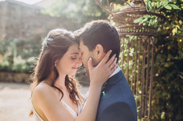 Elegant bride and groom posing together outdoors