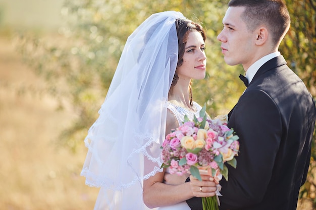 Elegant bride and groom posing together outdoors