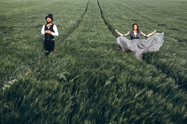 Elegant bride and groom walking and posing on green field