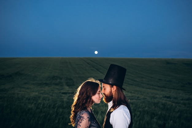 Elegant bride and groom walking and posing on green field