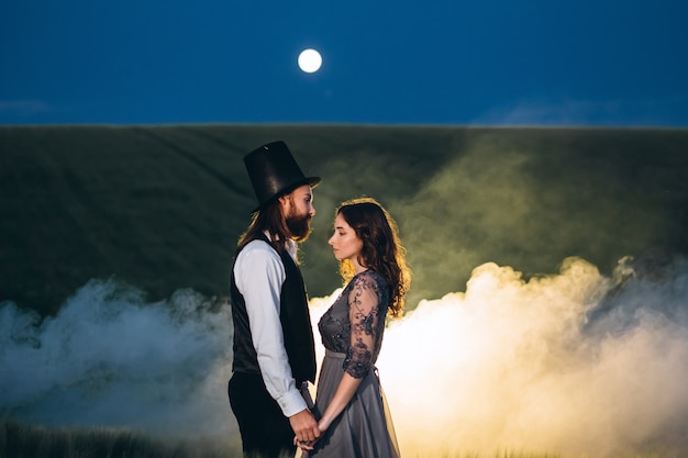 Elegant bride and groom walking and posing on green field