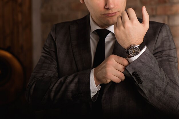 Elegant businessman correcting his cufflinks and sleeve.