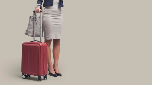 Elegant businesswoman traveling with a red trolley bag business travel concept blank copy space