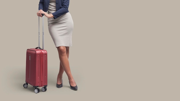 Elegant businesswoman traveling with a red trolley bag business travel concept blank copy space