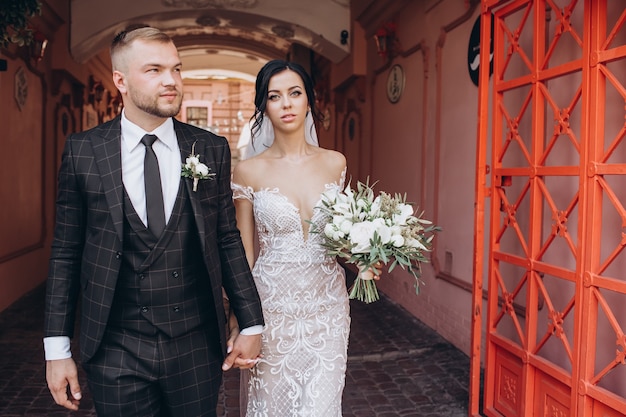 Elegant couple walking at sunset, love story, portrait of bride and groom on wedding day