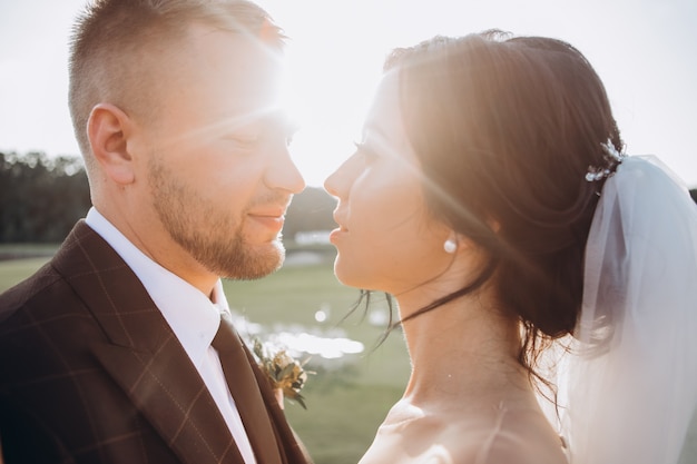 Elegant couple walking at sunset, love story, portrait of bride and groom on wedding day