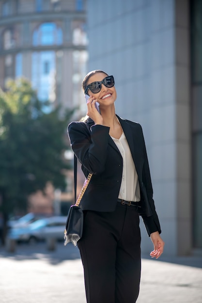 Elegant dark-haired woman talking on the phone