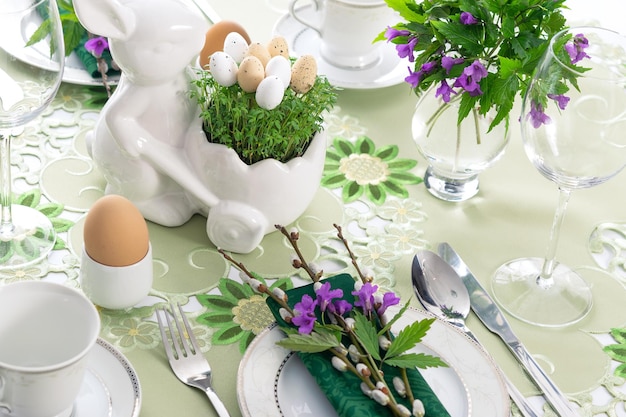 Elegant Easter holiday table settings decoration with fresh early spring violet flowers cress leaves and eggs