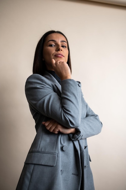 Elegant fashion portrait of a woman in grey dress shirt and blazer with brown hair and electric blue