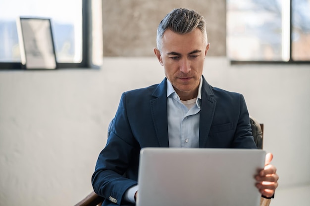 Elegant goodlooking man in a suit working in the office