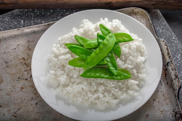 Elegant Harmony Top CloseUp of Steamed White Rice with Cooked Snow Pea on Top Presented in 4k