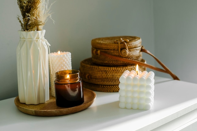 Elegant home decoration with wooden wick burning candle in brown glass jar and babble candles